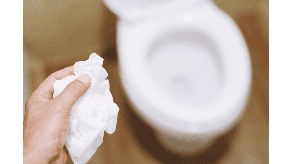 person throwing baby wipes in toilet