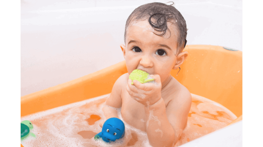 baby chewing on bath toy