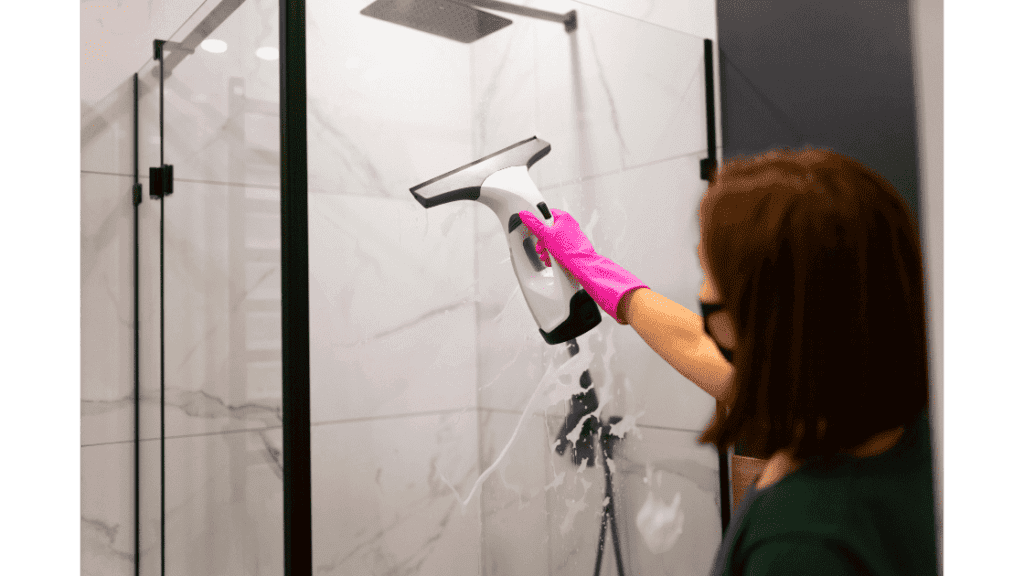 Cleaning glass shower door with squeegee